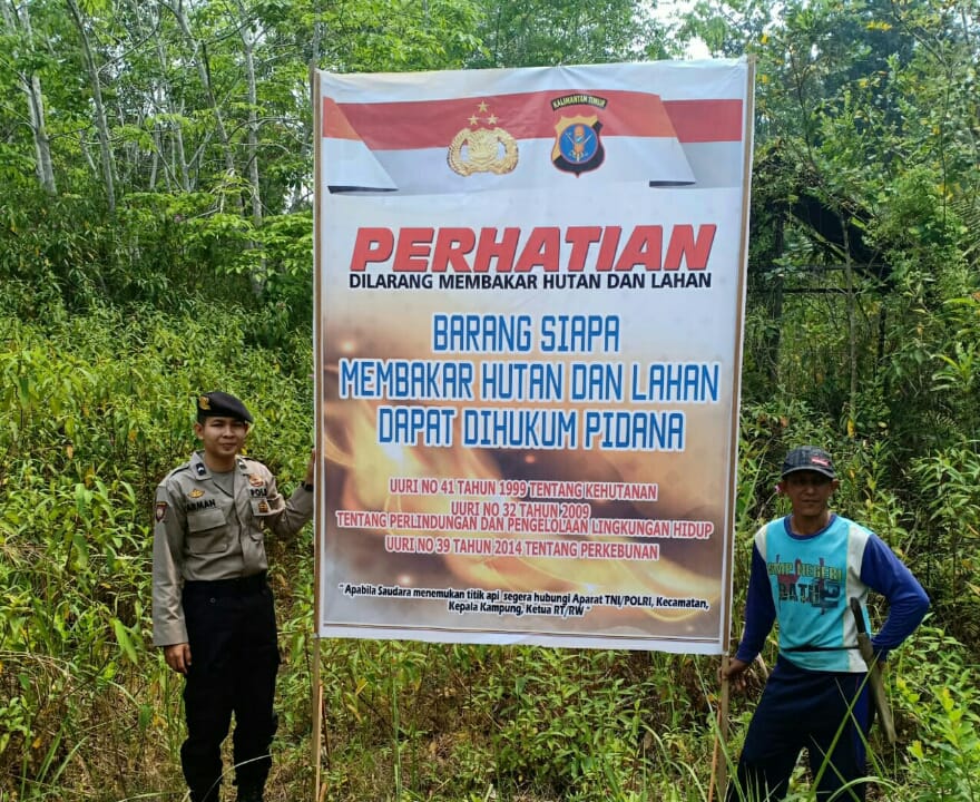 Anggota Polsek Penyinggahan memasang spanduk himbauan Karhutlah